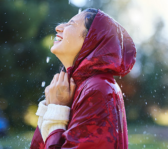 今天是享受人生的好日子 一位年轻女子在外边享受雨景的镜头背景图片