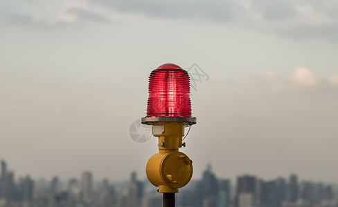 高层建筑屋顶安装的红色障碍灯灯笼 确保飞行安全 并在城市景观背景下警告飞机的危险标志摩天大楼天空电气建筑学高楼红灯日落设备技术图片