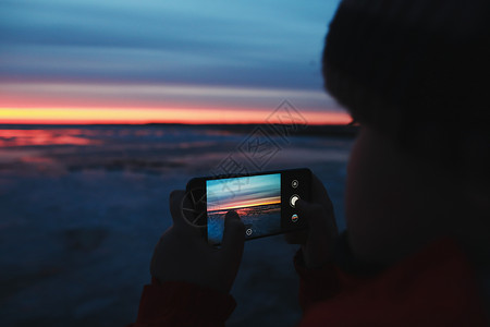男人用手机拍下海上日落天空的照片 渐变色 天空纹理 作为背景的美好的抽象自然日落背景