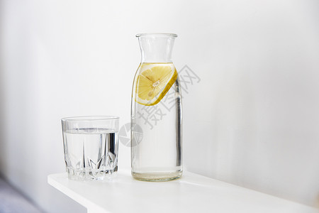 一杯清新水 一瓶里面有一片柠檬的瓶子 在夏热时放在梳妆台上背景图片