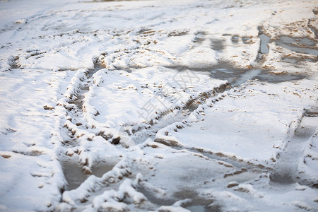 被雪覆盖的泥土路上的汽车翻转痕迹高清图片
