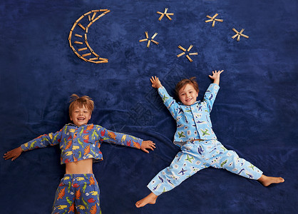 两个星星素材有着远大梦想的小男孩 两个小男孩躺在假想的月亮和星星下面背景