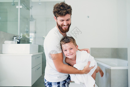父亲的身影在家浴室洗完澡后 一个英俊的年轻父亲擦干他可爱的小儿子的身影被拍下来了 (笑声)背景