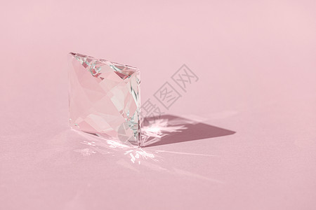 粉红色钻石具有光谱颜色光衍射和反射的水晶棱镜 具有时尚的光线和粉红色背景上的硬阴影 通过玻璃棱镜反射的光谱射线化妆品光束产品物理阳光几何学背景