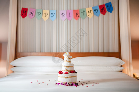 花瓣蛋糕庆祝生日 在床上惊喜 与生日快乐旗帜和毛巾蛋糕的床派对横幅装饰甜点字母丝带礼物生日蛋糕庆典酒店背景