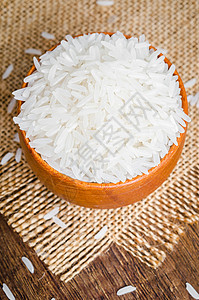 在木制桌上的碗里炒饭木纹纹理饮食健康饮食白米摄影圆圈桌子生食用具背景图片