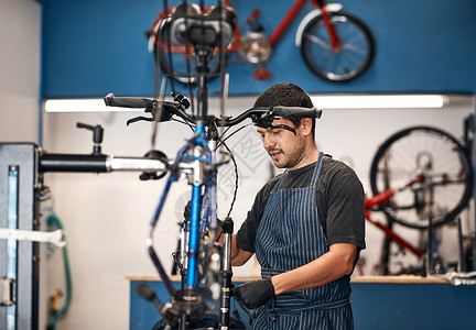 给予您的自行车应有的关注 拍摄一名在自行车修理店工作的男子背景