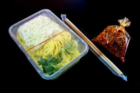 带酱汁的意大利面条 用塑料包装将食物带回家筷子红色美食盒子托盘背景图片