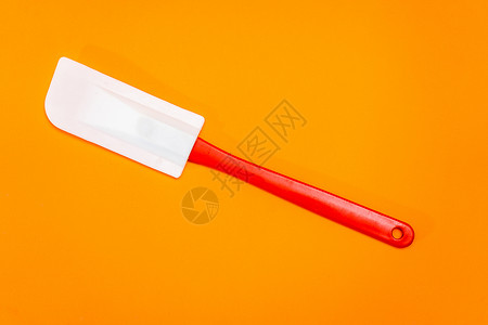 由橙色表面隔热的硅酮和塑料制成的红色和白色厨房烟缸背景