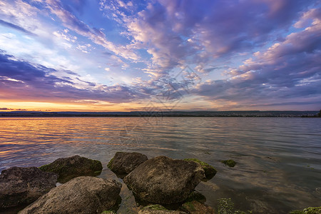 湖边的石头日落后湖边的洛奇海滩风景海景石头反射地平线蓝色悬崖岩石日落云景旅行背景