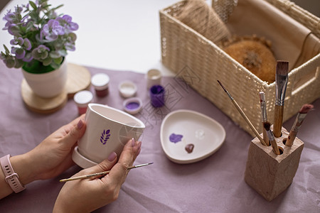 盒子紫色盒子女人手握着白花陶瓷锅在桌上背景