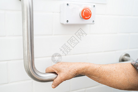 减值亚洲老年或老年老妇人病人在护理医院病房使用厕所浴室手柄安全 健康强大的医疗理念铁轨洗澡合金洗手间人士退休栏杆潮红照片金属背景