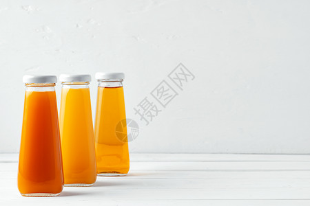 白色背景上不同果汁的玻璃杯瓶饮食婴儿橙子产品瓶子液体排毒水果饮料蔬菜背景图片