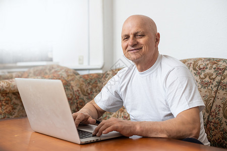老爷爷想独用互联网 却又在利用网路男人男性微笑网络老年好奇心花园幸福老人轮椅背景图片