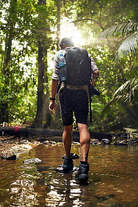 没有通往任何值得去的地方的捷径 在树林中探险时 一个无法辨识的徒步旅行者穿越溪流的回响镜头背景