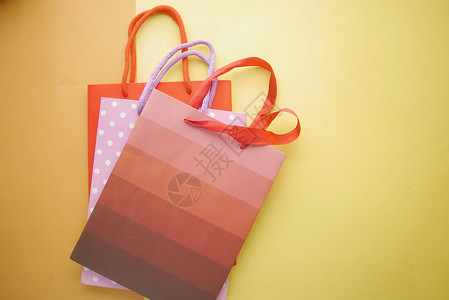 橙色背景的多颜色购物袋顶部视图背景图片