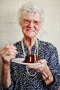 退休很适合我 一个年长女人在里面吃一块蛋糕的镜头背景图片
