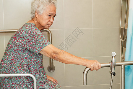 亚洲年长的老年妇女病人在浴室 手扶安全抓抢酒吧和护理医院使用马桶支持栏杆 70护士女士合金浴缸金属保健障碍洗手间医生苗圃图片