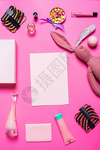 粉红背景的女孩的饰品玩具化妆品唇线时尚指甲油记事本手镯口红糖果衣服背景图片