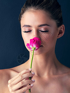 有时最简单的东西也是美丽的 工作室拍摄了一位迷人的年轻女子 装扮和闻到一朵美丽的粉红色玫瑰背景图片