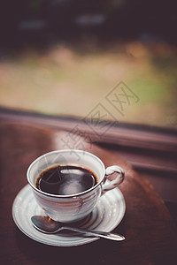 咖啡放在窗边的桌子上休闲时光毛毡杯子雨季时间窗户咖啡杯雨天零食背景图片