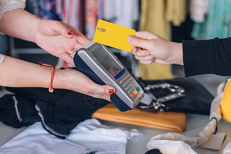 女售货员用信用卡兑现 女用无接触者支付 购物概念 近距离接近背景图片