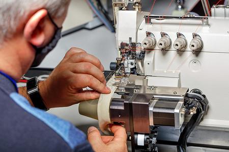 工头对现代缝纫机的正确操作进行调整高清图片