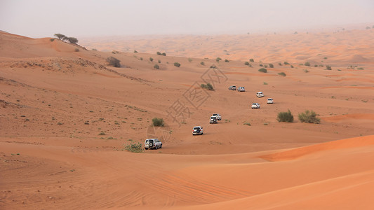 沙漠的车在阿拉伯沙丘中冲击背景