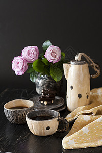 两杯黑咖啡 黑色巧克力 一个黄茶壶和一个花瓶 底底有粉红玫瑰餐巾咖啡机黄色坚果早餐休息玫瑰杯子背景图片