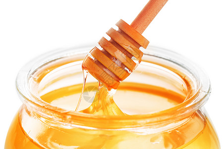 在白色背景上隔离的带有甜蜜的玻璃罐蜜蜂桌子产品液体金子蜂蜜花蜜木头食物甜点背景图片