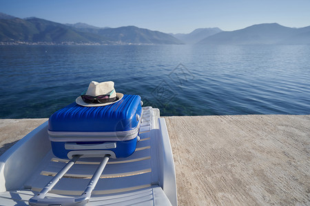 黑山亚得里亚海岸一个遮晒员的蓝色行李箱 旅行概念;在背景图片