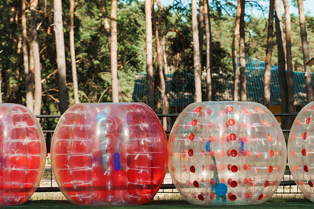 绿色球场上泡泡球气球 团队建设运动游戏设备 名称为保险杠球或泡沫球优胜者行动太空滚球娱乐草地乐趣塑料闲暇竞赛背景图片
