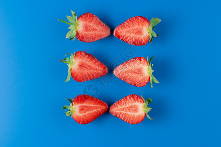 蓝底的草莓切片切片收成水果浆果绿色桌子味道团体健康季节性蓝色背景图片