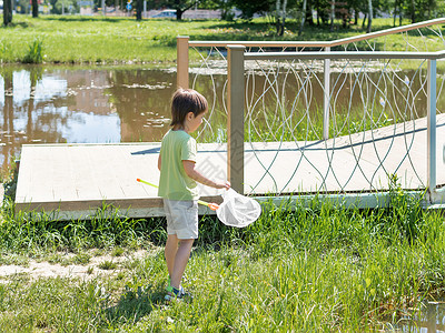 捕蝶网好奇的孩子在户外用蝴蝶网散步 儿童暑假休闲活动 昆虫狩猎背景