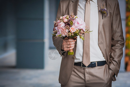 大卫奥斯汀玫瑰新婚夫妇的手和婚礼花束背景