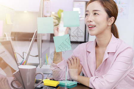 商业界女性脑力风暴在蓝纸条和粘贴纸条上写笔记 在办公室里做笔记的女商务人士们集思广益战略成人人士金融团队微笑木板头脑写作商务背景图片