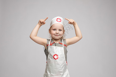 幼儿园是素材穿着医生制服的可爱女孩 她是个医生情感幼儿园乐趣闲暇手势女性药品手臂微笑围裙背景