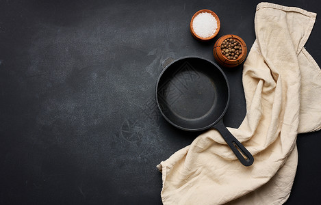 花藤圆环黑白黑白黑色圆环煎铁锅 在黑桌顶视图上摆有把手 复制空格背景