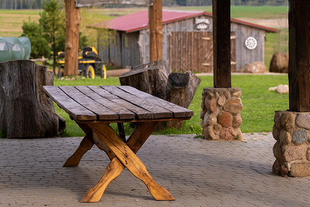 木制桌子和草地一张桌子 站在一块露天木制长袍上 站在地产旁边的土地上背景