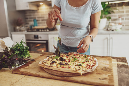 妇女在家里生产传统自制披萨的裁剪镜头高清图片