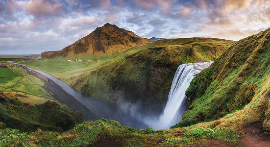 七月旅行季冰岛南部靠近冰岛的Skogafos大瀑布瀑布老年旅行阳光男人游客蓝色天空溪流环境背景