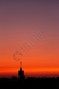 闪耀霍达斯紫色红色夏日日出 城市上方一座旧教堂塔的顶楼天际地平线建筑学建筑阳光太阳日落教会天空地标背景