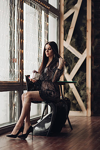 黑裙子和高跟鞋的棕发美女模特儿 在椅子上庆典工作室黑发外表风格装饰扶手椅女孩蕾丝奢华背景图片