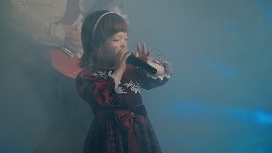 青年才俊穿旧礼服的小女孩在舞台上唱歌 她父亲弹电吉他衣服金属裙子戏服背景音乐会油烟机服装乐器重音乐背景