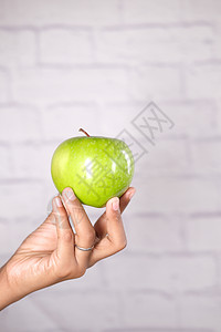 男孩手握着蓝底的苹果食物绿色蓝色棕榈男生水果背景图片