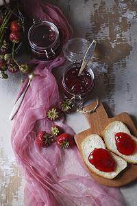 夏季早餐概念 用草莓果酱加面包和新鲜收获的红布浆果背景图片