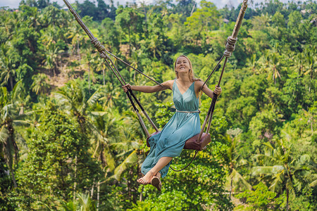 绳索摆动年轻女子在印度尼西亚巴厘岛的丛林雨林中荡秋千 在热带摇摆 秋千巴厘岛的潮流旅行冒险假期肾上腺素吸引力乐趣闲暇青少年森林荒野背景
