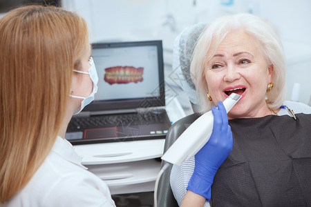 工作时的女牙医女士植入物扫描医生治疗医疗牙科老年保险牙齿背景图片