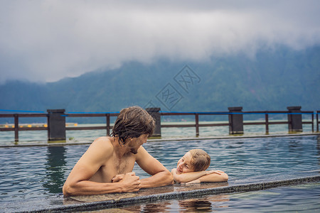 班加尔堡父亲和儿子旅行者在巴厘岛温泉的湖边背景 与儿童一起旅行概念纪念碑喷泉水池女士雕像孩子文化地标传统洗澡背景