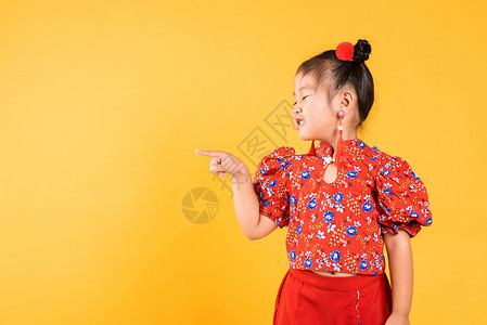 宝微女装素材亚裔快乐的中国小女孩穿红色长相齐宝 指着太空女士节日手势戏服商业裙子微笑衣服女孩文化背景
